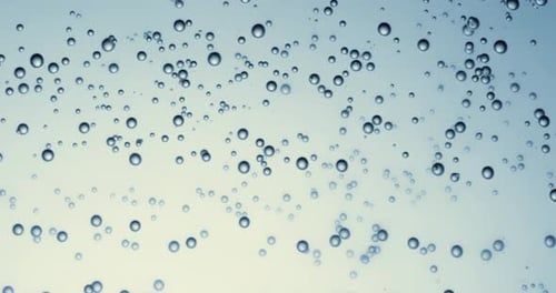 Many water bubbles in blue water close up, abstract water wave with bubbles in slow motion.