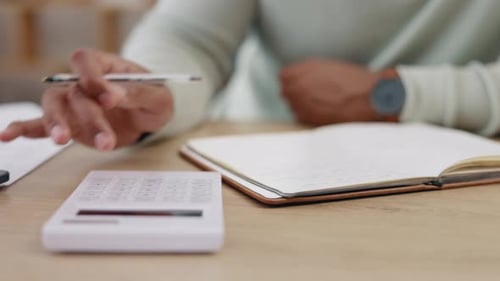 Hands Calculate Finances and Write in Notebook