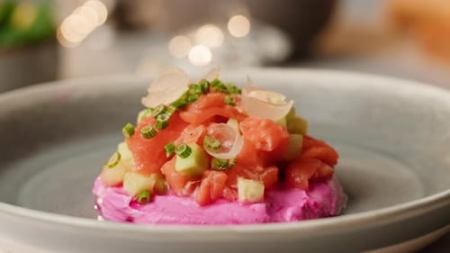 Chilenisches Lachstatar-Seviche mit Avocado und Gurke auf lila Frischkäse mit Frühlingszwiebeln