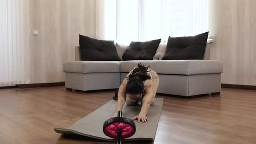 Woman Exercising at Home with Ab Roller