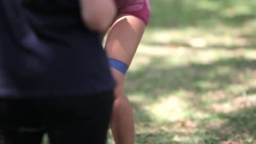 Woman Exercising Legs with Resistance Band Outdoors