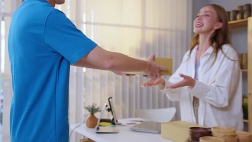 Caucasian young woman receive a box form deliverly man in store house.