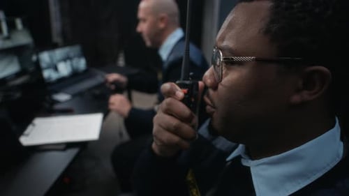 Security Staff Monitoring Surveillance in Dark Control Room