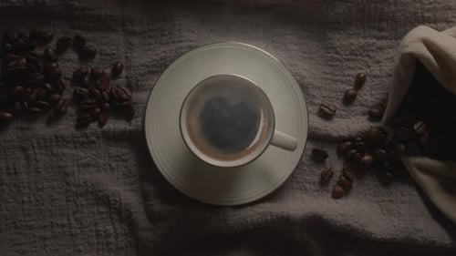 Coffee Cup with Beans on Gray Cloth