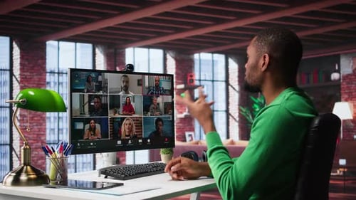 Man Attends Virtual Meeting On Computer At Desk
