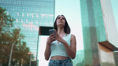 Woman Uses Phone in Modern City Environment