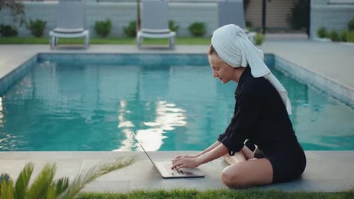 Woman Working on Laptop by Swimming Pool