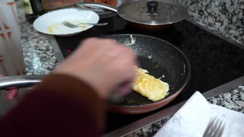 Close up shot of old woman hands cooking omelet in pan. Handheld