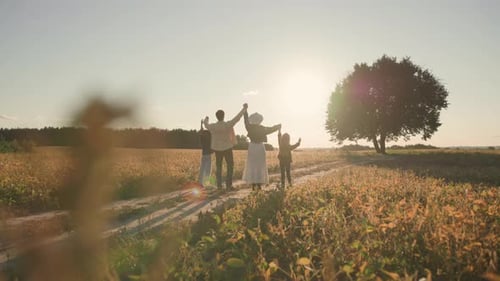 Affectionate Happy Family of Mother and Father and Their Amazing Children Holding Raised Hands