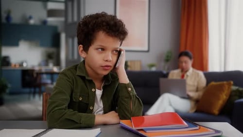 Curly Haired Boy Talking on the Phone at Home