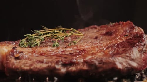Fresh Marbled Beef with Pepper Salt and Rosemary Closeup Macro Cooking Juicy Steak on Grill with Oil