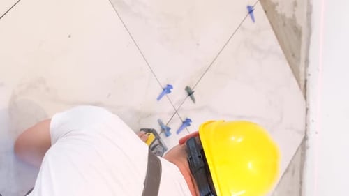 Construction Worker Using a Level for Tiling