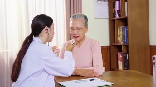 Woman Doctor Checks Senior Woman with Stethoscope Indoors