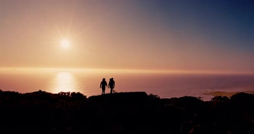 Couple, silhouette and hiking on mountain at sunrise with ocean, sky and mockup space on vacation
