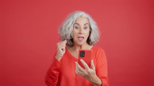 Mature Woman Celebrating While Using the Mobile Phone