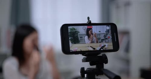 Hermosa bloguera asiática está mostrando cómo maquillar y usar cosméticos