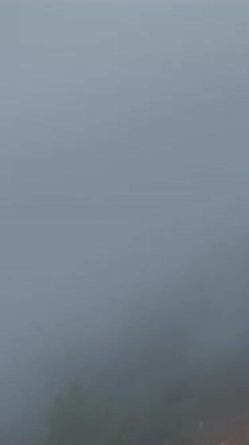 Vertical Video High in the Mountains Clouds Float Over Green Forests Under a Clear Blue Sky in a