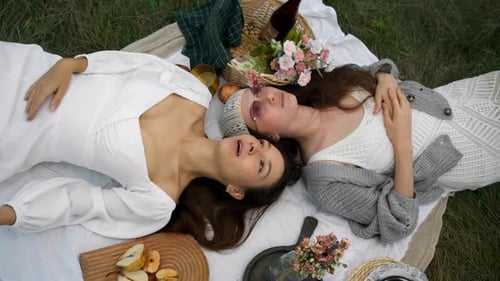 Women Relaxing on a Picnic Blanket in a Field