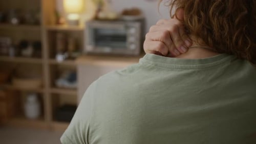Woman Massaging Neck and Shoulder Inside Home