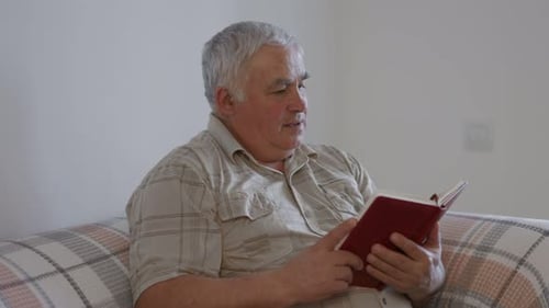 Homely Enlightenment Senior Man Reading a Book in the Comfort of Home