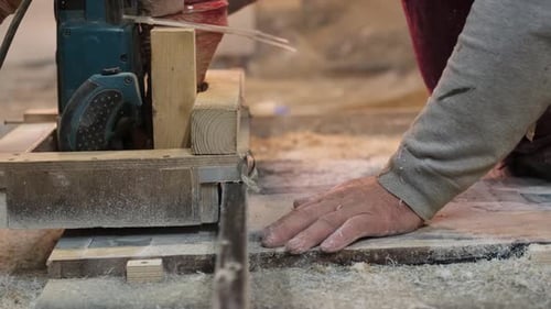Die Hände eines Holzarbeiters bedienen eine Säge Der Fokus auf Details unterstreicht die Bedeutung der Sicherheit bei der manuellen Bearbeitung