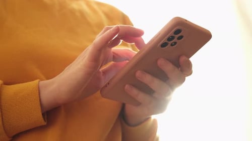 Hands Using Cellphone Indoors in Bright Light