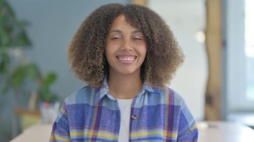 Young Woman with Curly Hair Smiling at the Camera