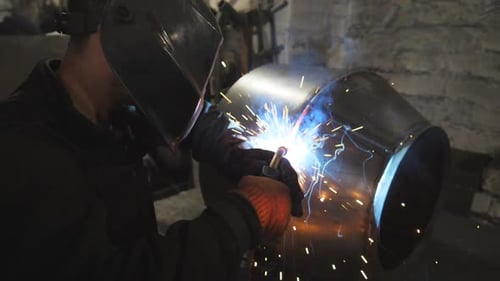 Arbeiter im Bereich Schutzmaskenschweißen, Metallbau bei industrieller Produktion, Schweißer bei der Schweißverbindung