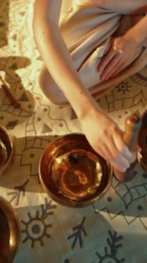 Woman playing a singing bowl outdoors during the daytime