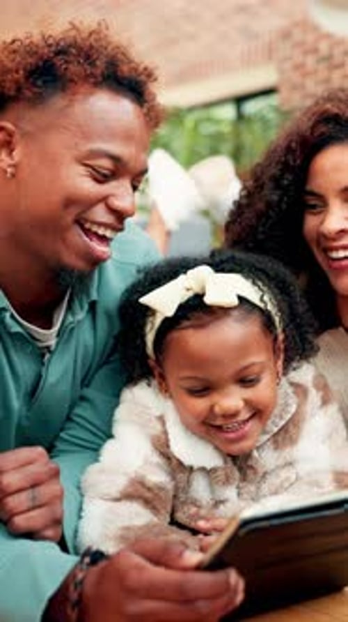 Smiling Family Looking at Tablet Together Indoors