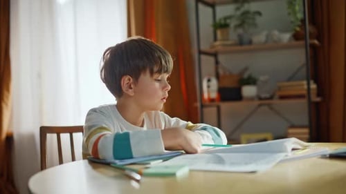 Unmotivated Pupil Reading Textbook Doing Homework Sitting Home Kitchen Closeup