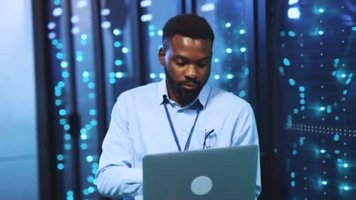 Man with Laptop in Data Center Working