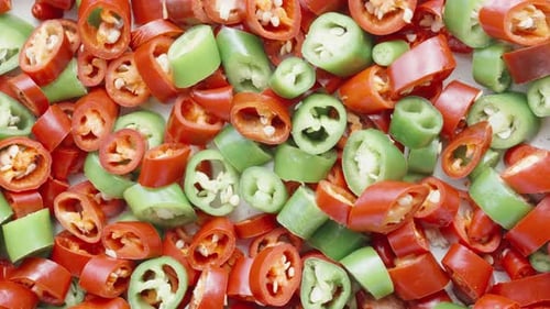 Sharp red and green peppers cut into round pieces, rotate.