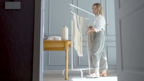 taller de una persona creativa, una mujer hace macramé