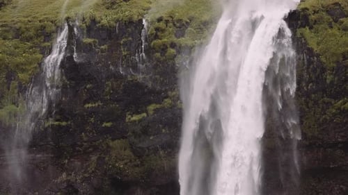 Majestic Waterfall Flowing Down Lush Green Cliffside