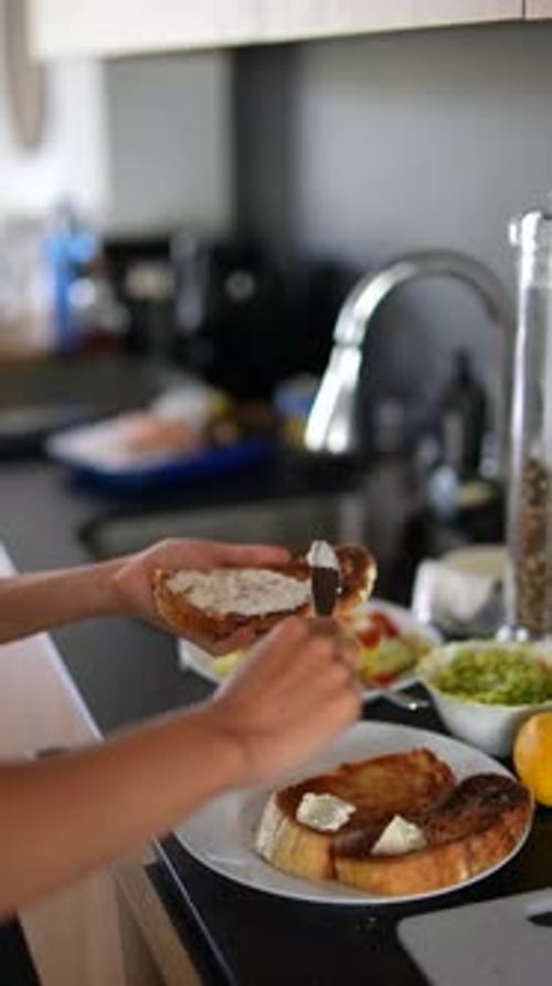 Woman Prepares Cream Cheese Breakfast Toast in Kitchen