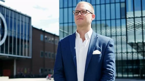Young Successful Businessman in Suit Standing Outside in Business City District