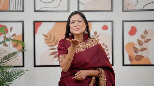 Woman in Sari Waves and Blows a Kiss