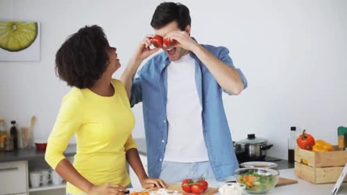 Couple Cooking Together in Kitchen with Tomato Fun