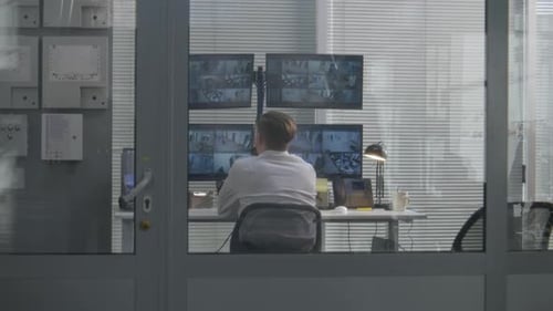 Security Guard Monitors Bank of Security Footage