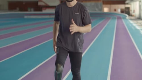 Athlete with Prosthetic Leg Walking in Place with High Knees Indoors