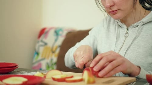 Woman Slices an Apple in Kitchen