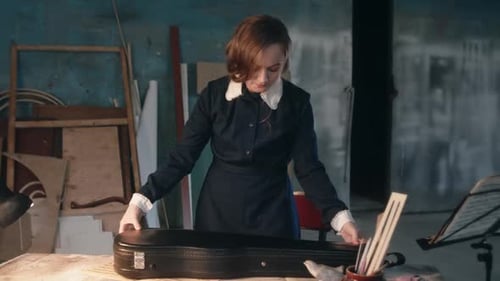 Woman Opens Violin Case and Inspects Violin