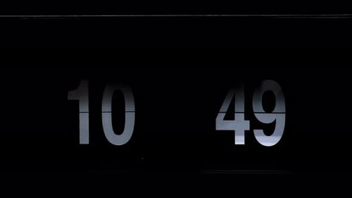 Flipping clock on a black background, in the style of time-lapse video.