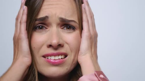 Stressed Woman Holding Hands on Head in Studio. Worried Woman Having Stress