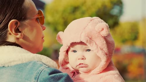 Portrait of a Little Newborn Girl with Her Mother in an Autumn Park