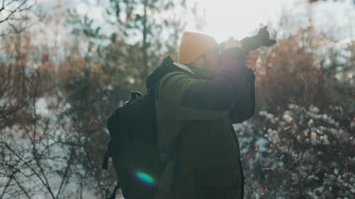 Man Taking Pictures in Snowy Winter Forest