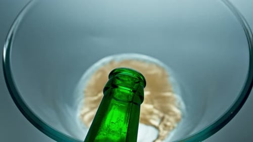 Pouring Beer From Green Bottle Into Glass
