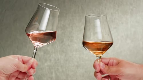 Bouteille et verre de vin rose orange ou blanc contre un coucher de soleil dans un vignoble paisible