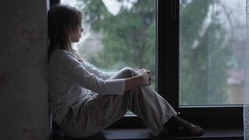 девочка-подросток одна в комнате, смотрит в окно, грусть